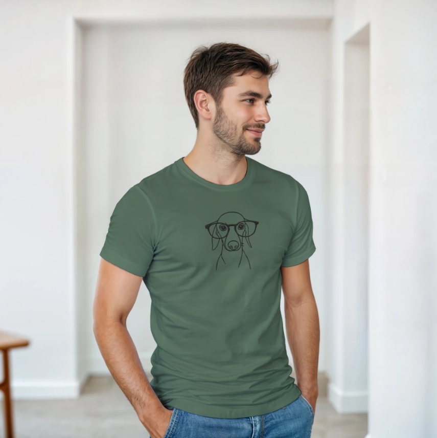 Man wearing a green personalized dog line art t-shirt indoors, featuring a minimalist custom pet illustration on the front.